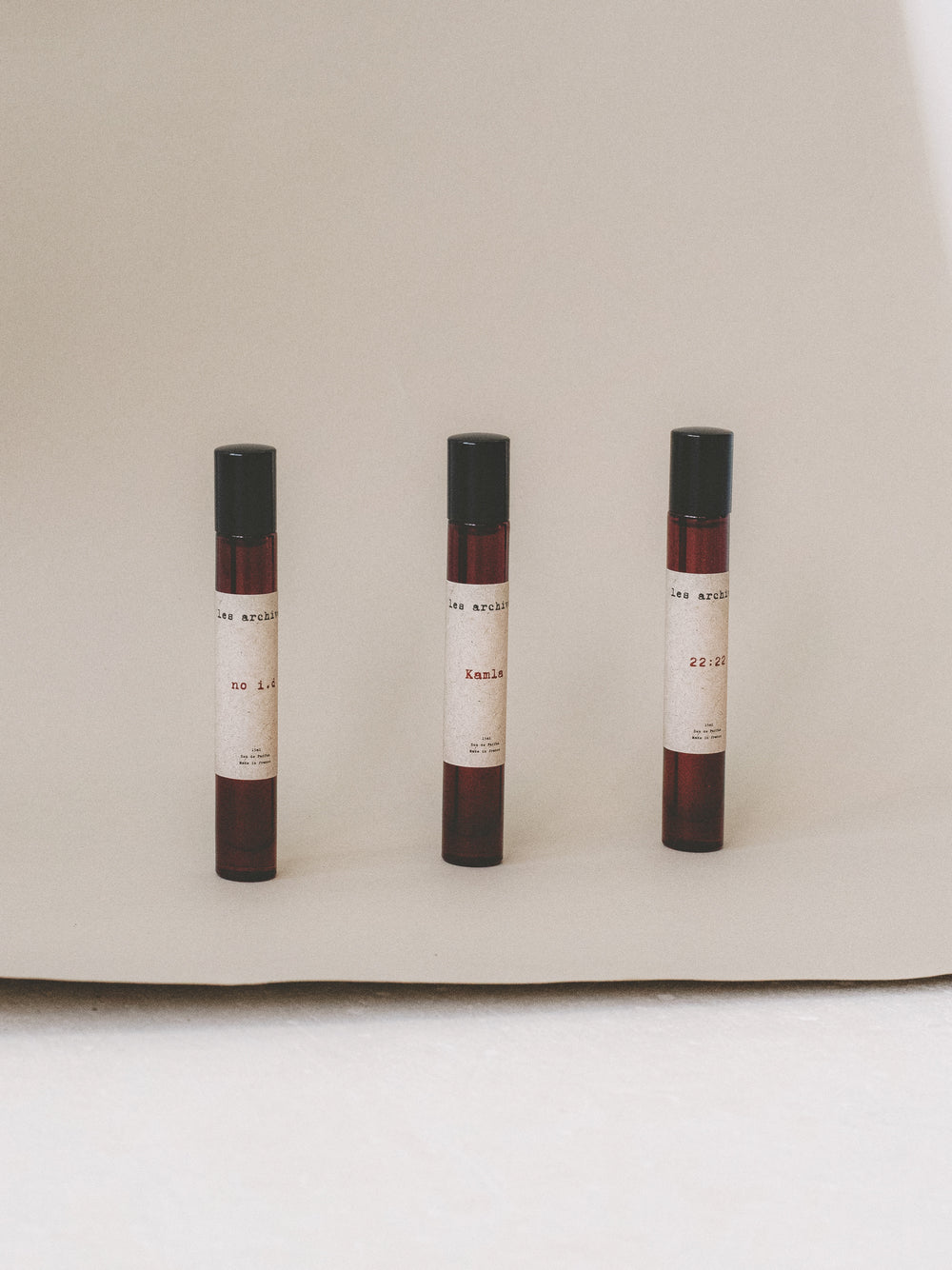 Formats voyage en 15ml des parfums Les Archives no i.d, Kamla et 22:22, présentés côte à côte sur un fond neutre en studio.