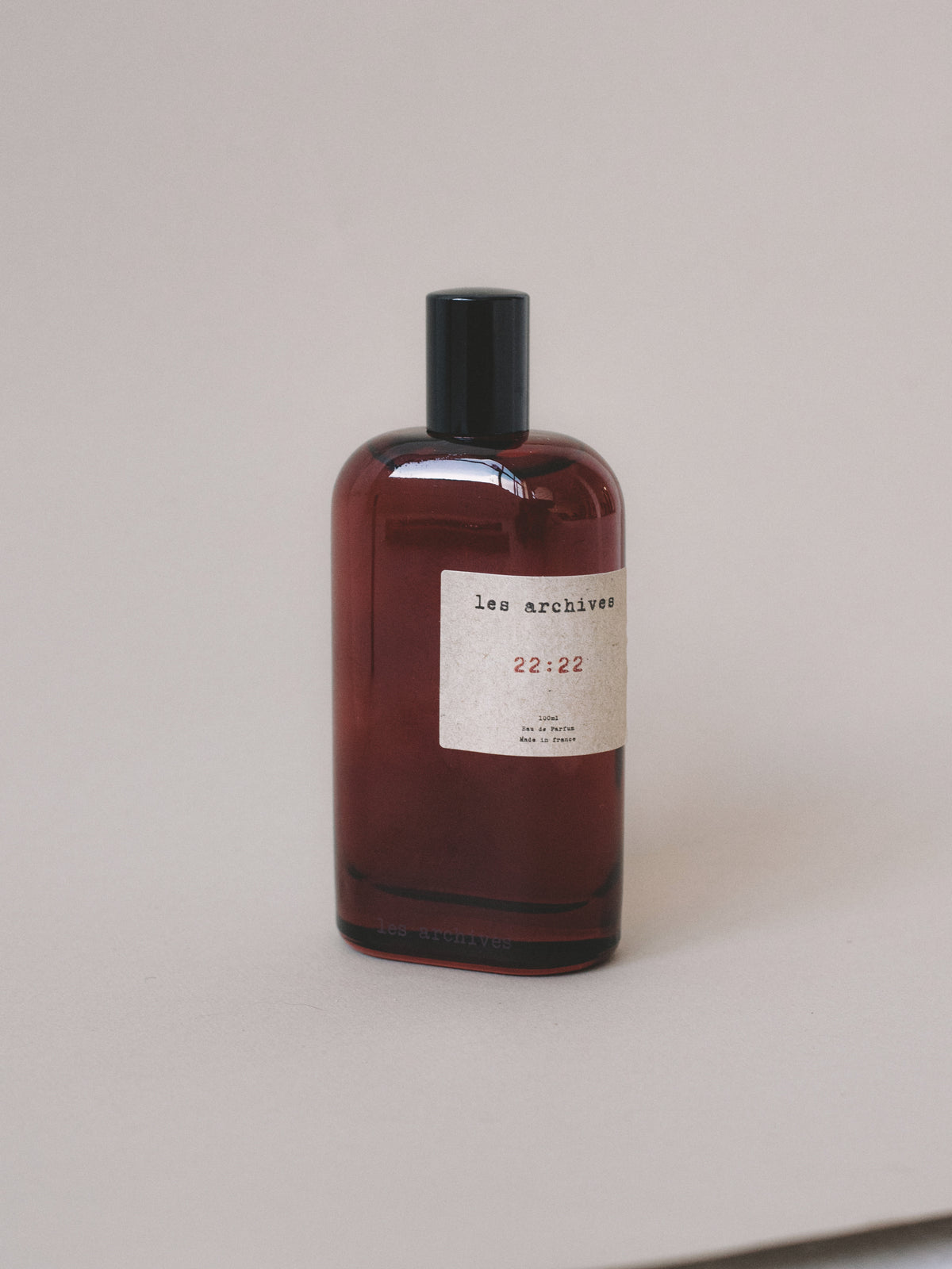 Parfum Les Archives 22:22 en 100ml – flacon en verre fumé rouge, photographie produit.
