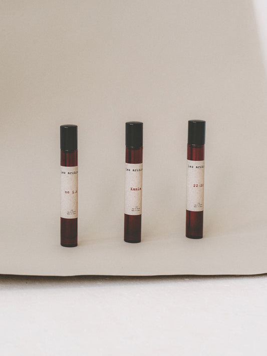 Formats voyage en 15ml des parfums Les Archives no i.d, Kamla et 22:22, présentés côte à côte sur un fond neutre en studio.