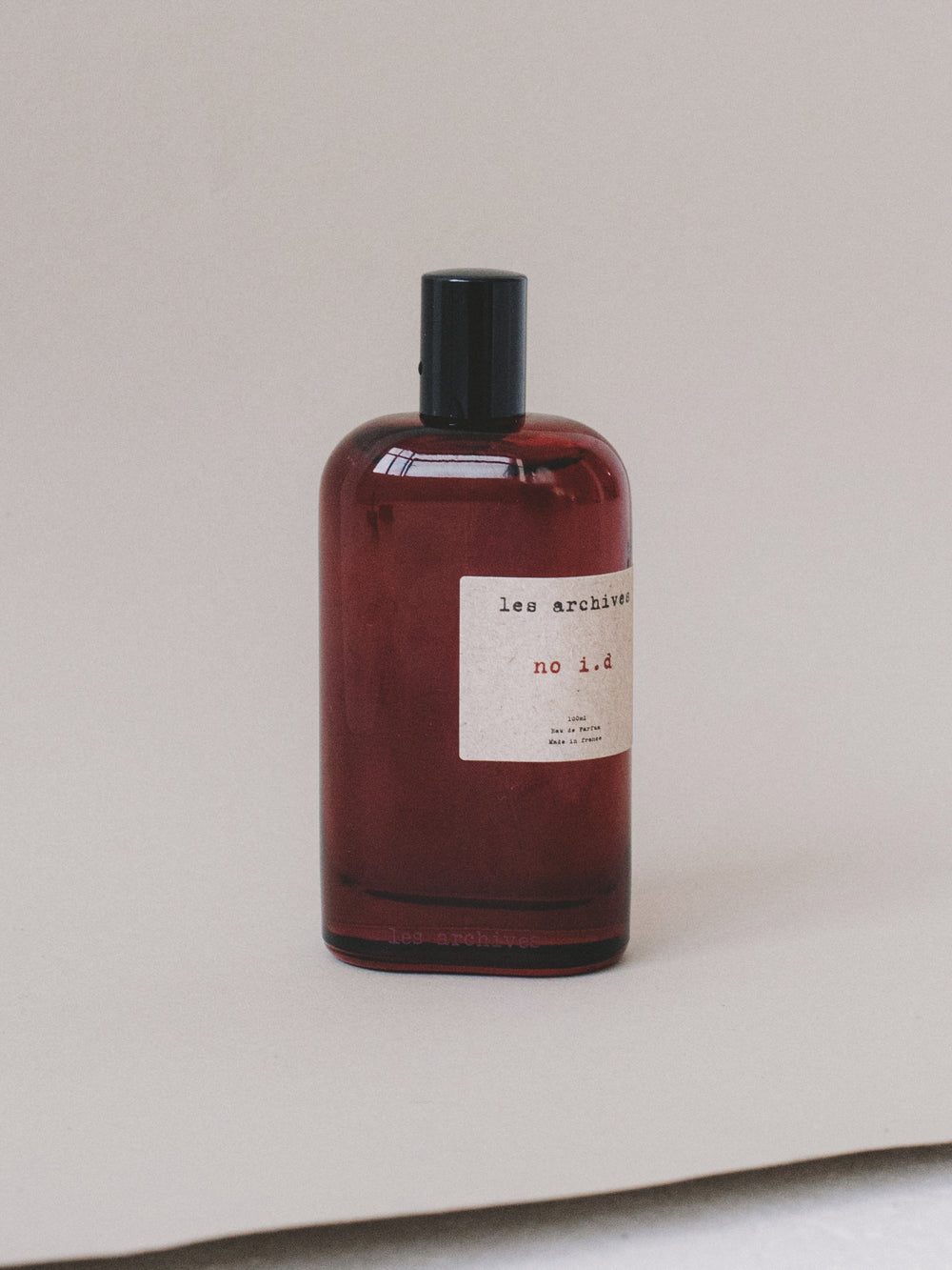 Parfum Les Archives no i.d en 100ml – flacon en verre fumé rouge, photographie produit.